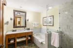 The luxurious bathroom includes a large custom shower and separate tub for ultimate relaxation after a day on the slopes
